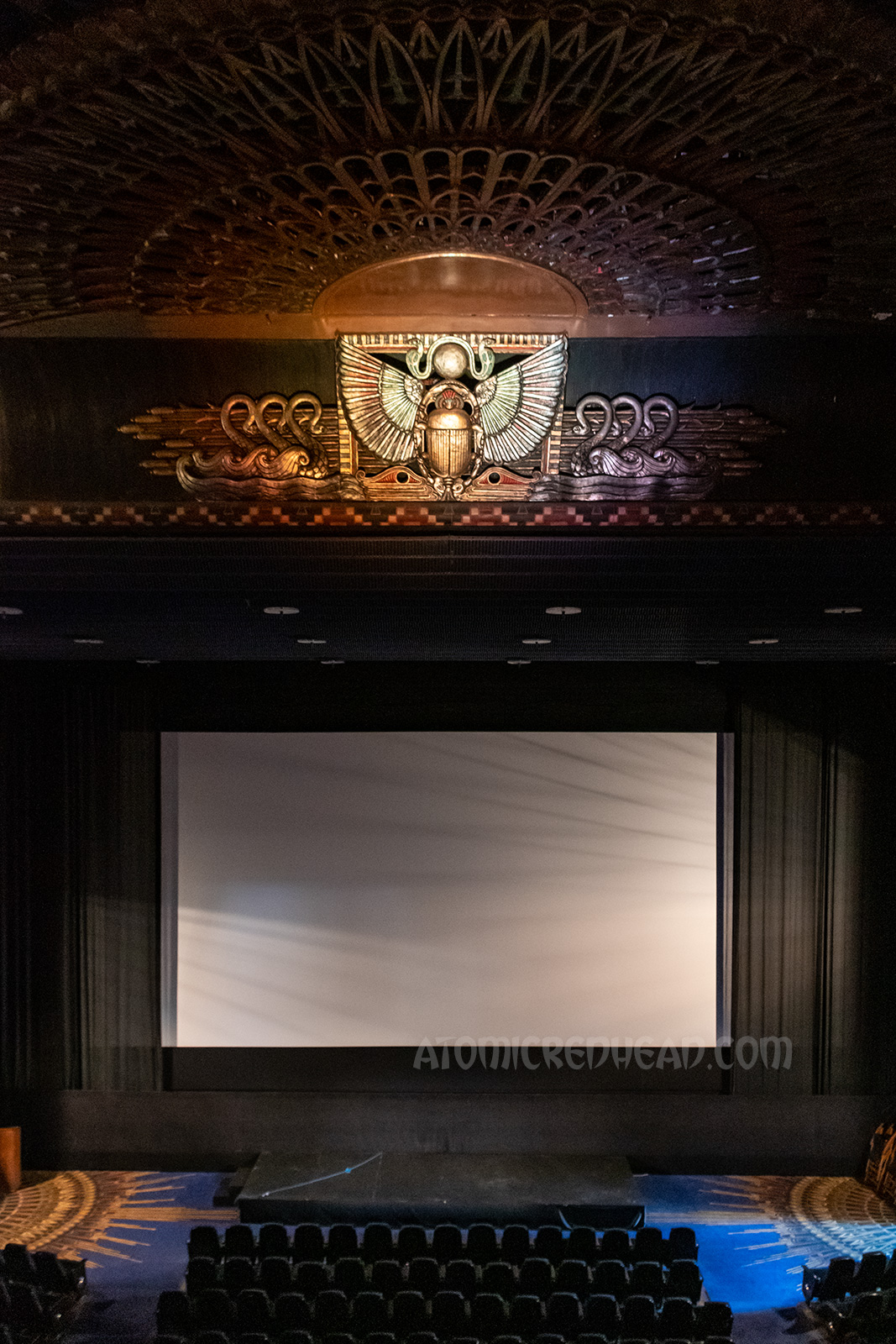 Image of the movie screen with the sun and scarab above.