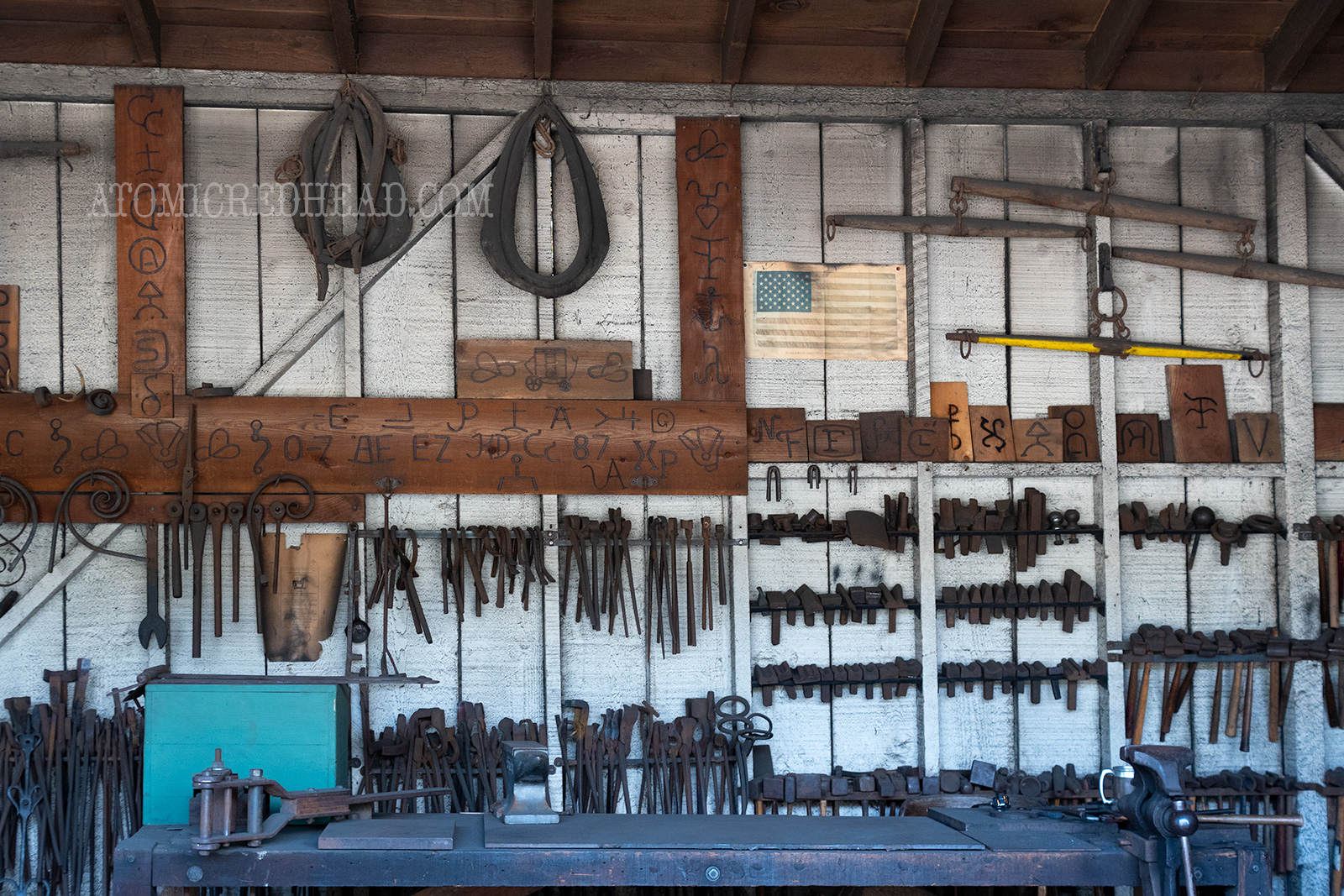 Harnesses, and tools hang on the wall of the blacksmith shop.