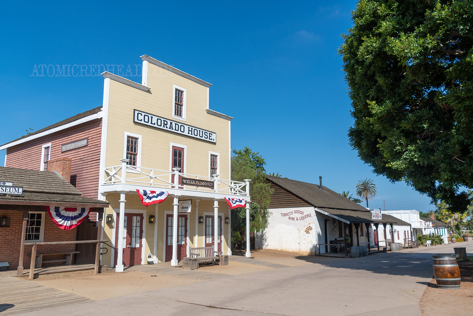 A tall two story building with a classic western facade, painted pale yellow. It reads "Colorado House" across the front.