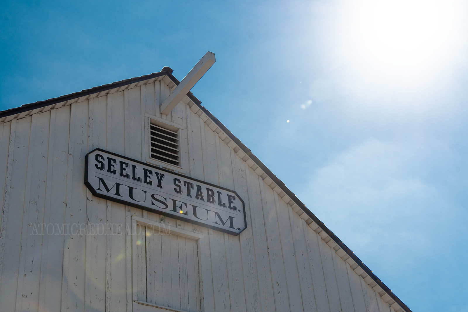 The top of a white barn, with a sign reading "Seeley Stable Museum"