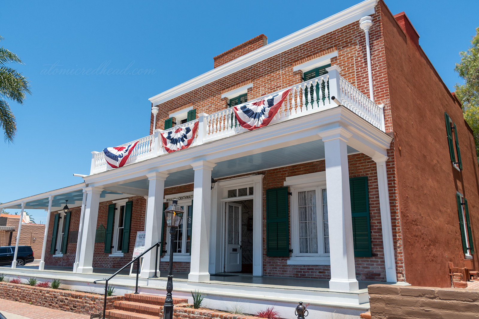 The Whaley House, a small, but stately looking home made of brick featuring a white column porch.