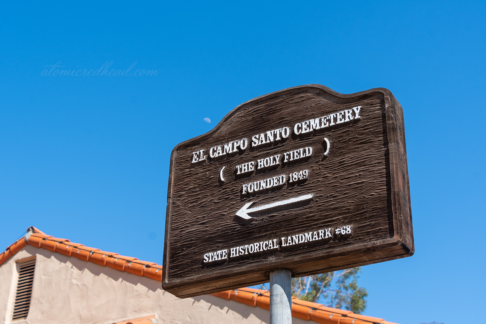 A wooden sign reads "El Campo Santo Cemetery (The Holy Field) Founded 1849 State Historical Landmark #68"