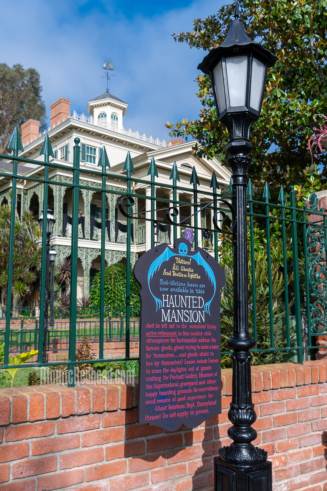 Out front a replica of a sign that appeared after the construction of the exterior building, reading "Notice! All Ghosts And Restless Spirits Post-lifetime leases are now available in this Haunted Mansion don't be left out in the sunshine! Enjoy active retirement in this country club atmosphere - the fashionable addres for famous ghosts, ghosts trying to make a name for themselves...and ghosts afraid to live by themselves! Leases include License to scare the daylights out of guests visiting the Portrait Gallery, Museum of the Supernatural, graveyard and other happy haunting grounds. For reservations send resume of past experience to: Ghost Relations Dept. Disneyland Please! Do not apply in person."