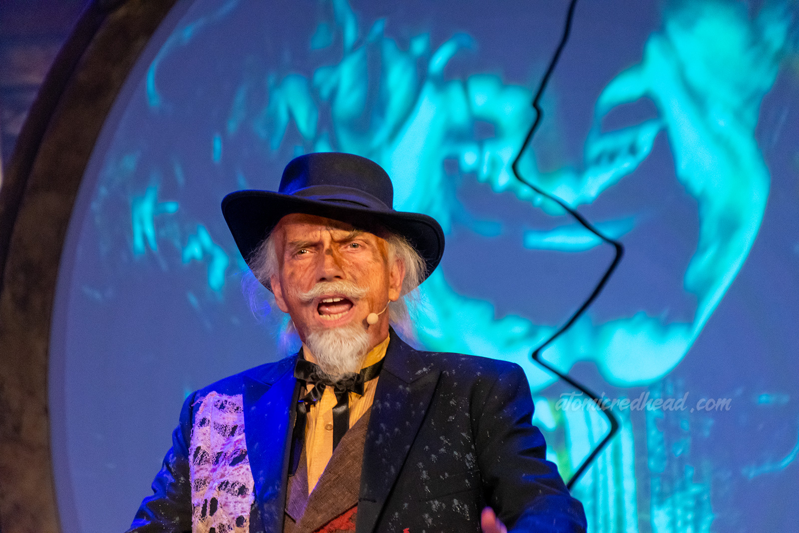 The judge of Calico dons a black overcoat, black hat, waistcoat, and string tie. He tells the people there will be justice.