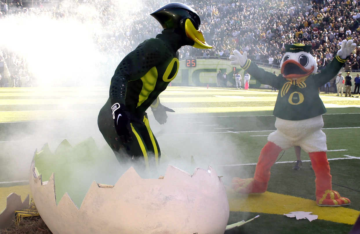 A muscular humanoid duck of green and yellow emerges from a large egg.