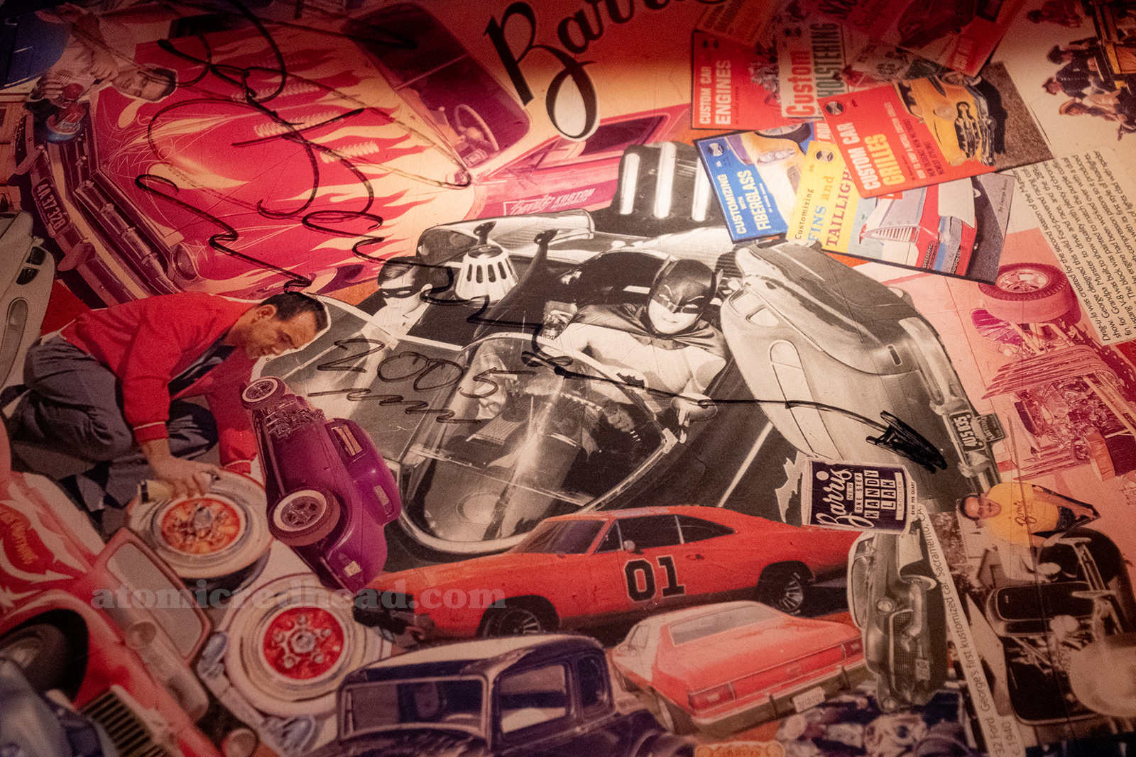 Close-up of one of the table collages that feature the cars of George Barris, and is signed by him.