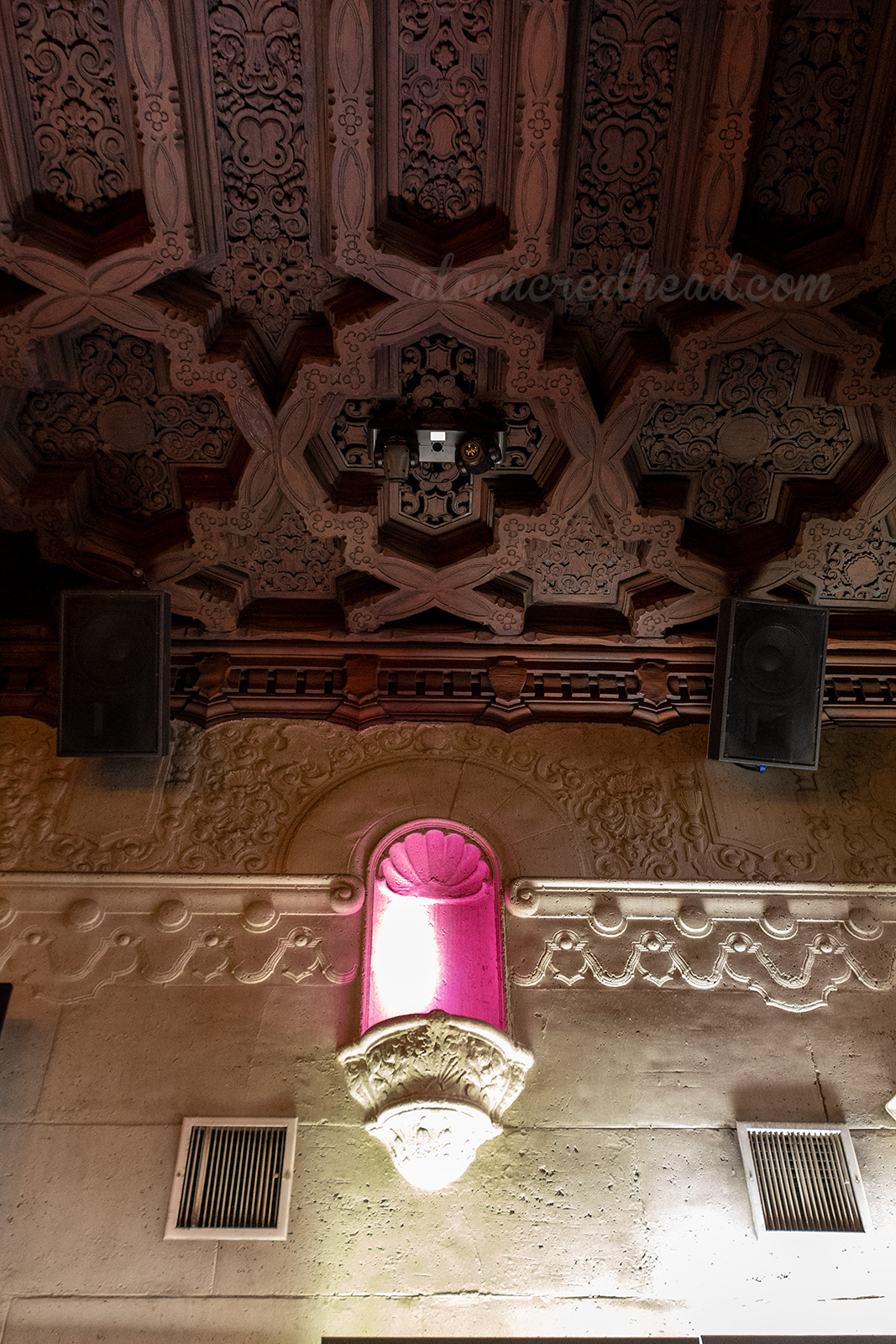 The elaborate carved wood ceiling, and almost cathedral like stone work with a lighted niche.
