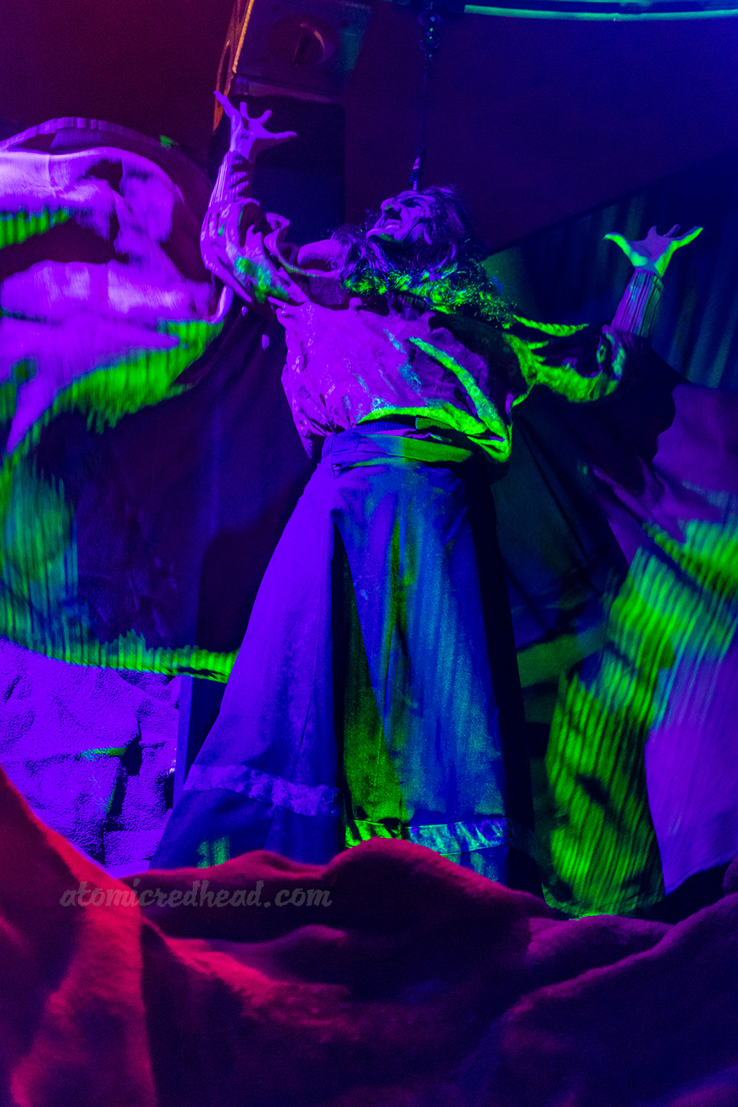 The Green Witch flies above those who dare to enter Origins.