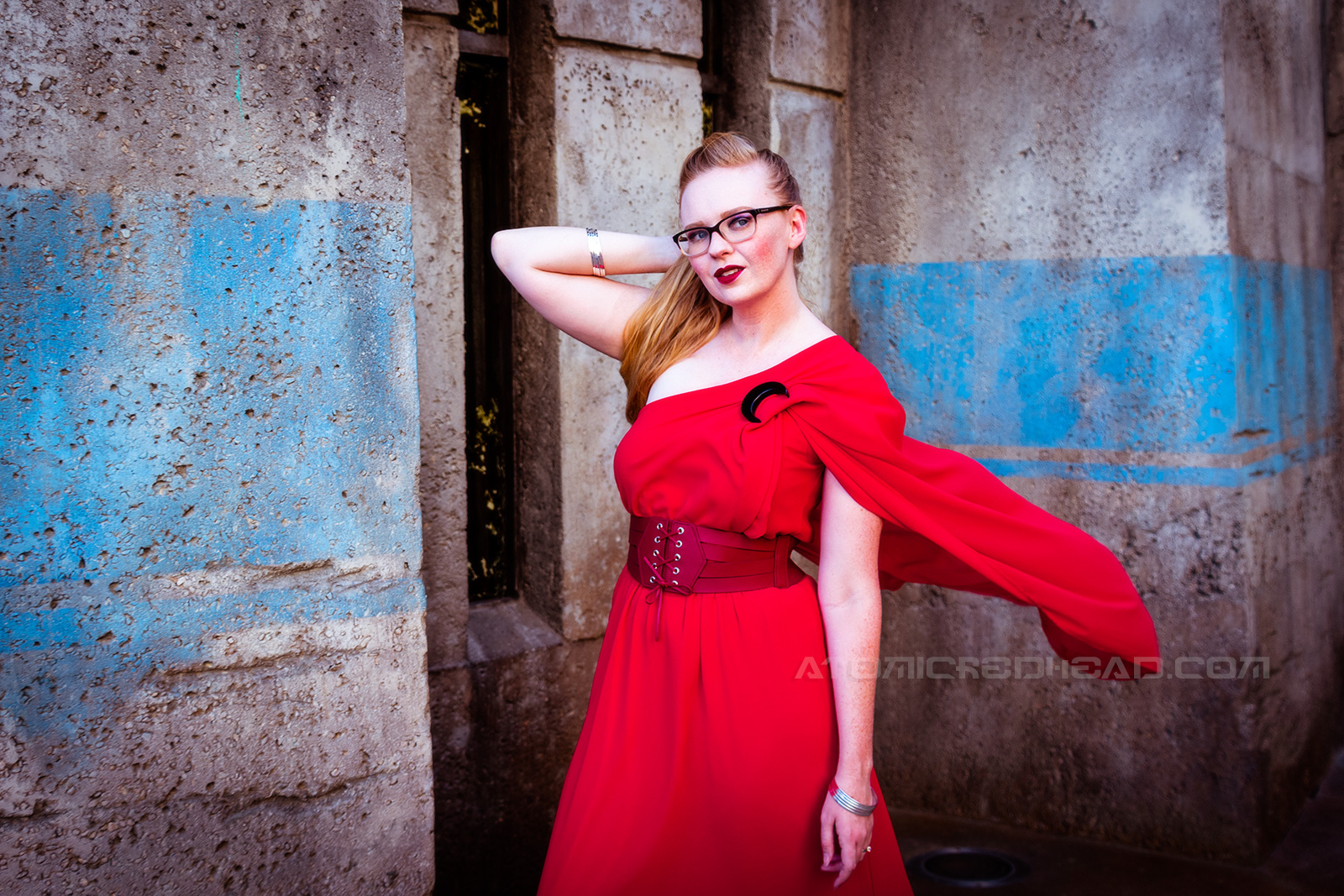 Myself wearing a full length red gown, it is asymmetrical with one shoulder ending in a short cape. A corset style belt at my waist, and a black crescent moon brooch at the shoulder.