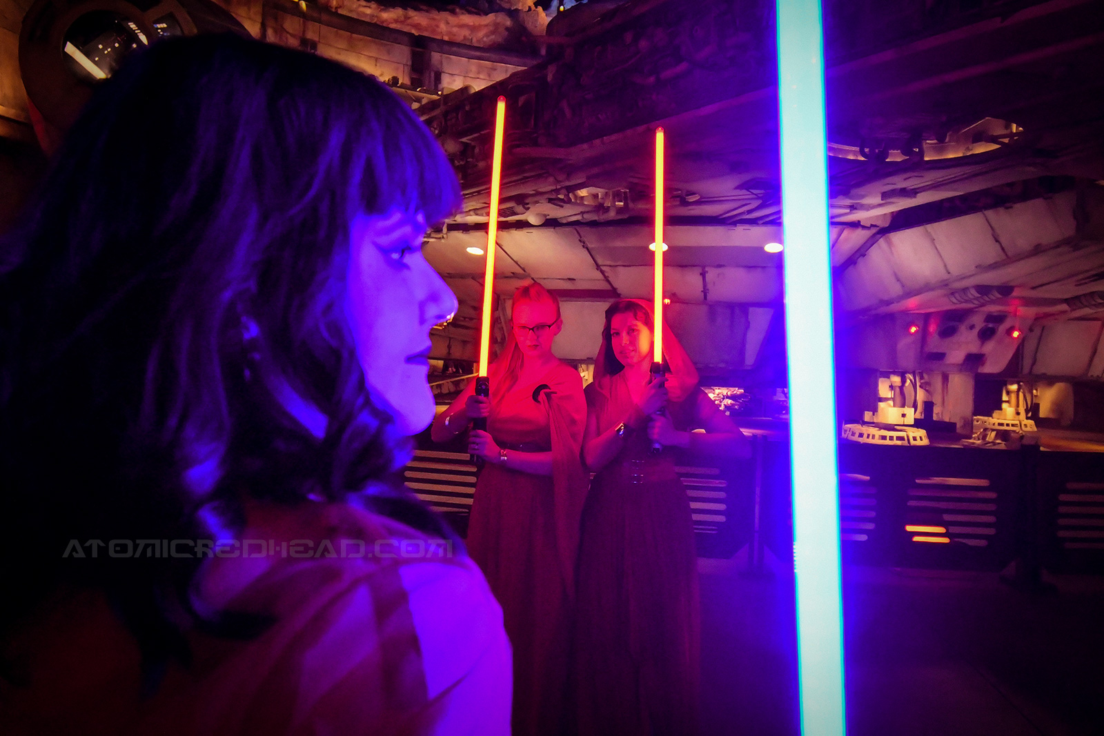Brittany with her blue light saber holds it near the camera, while Solanah and I with our red lightsabers stand, almost ready to strike in the background.
