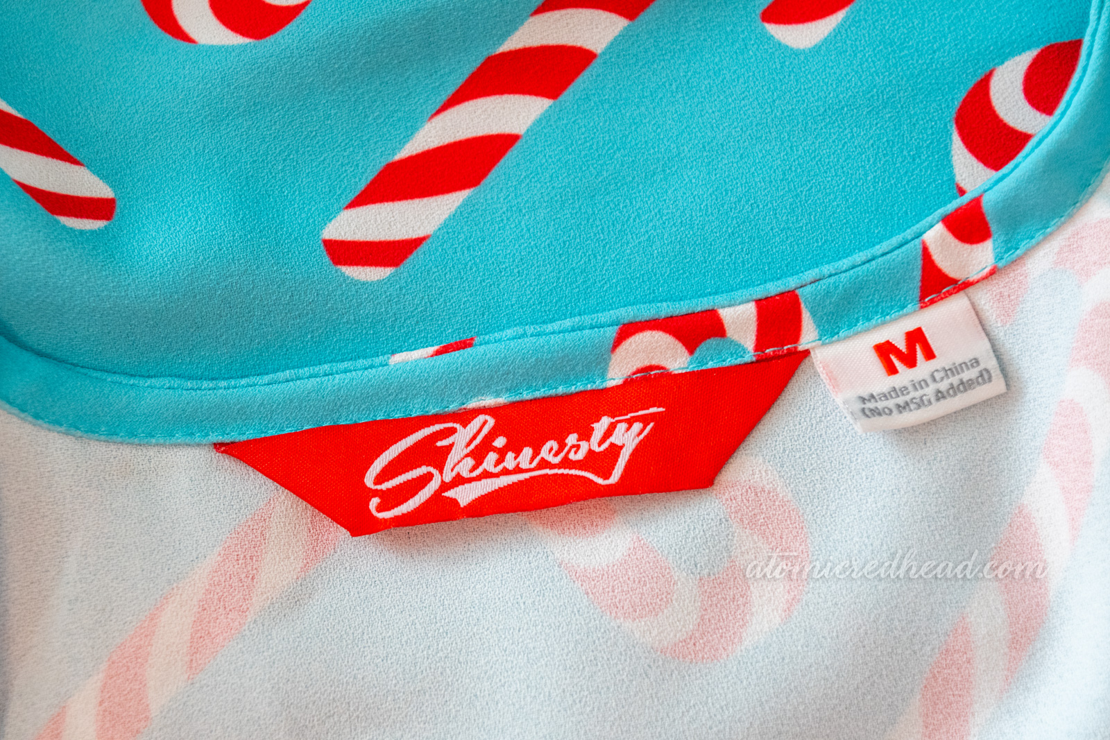 Close-up of the Shinesty label, reading size medium and "Made in China"