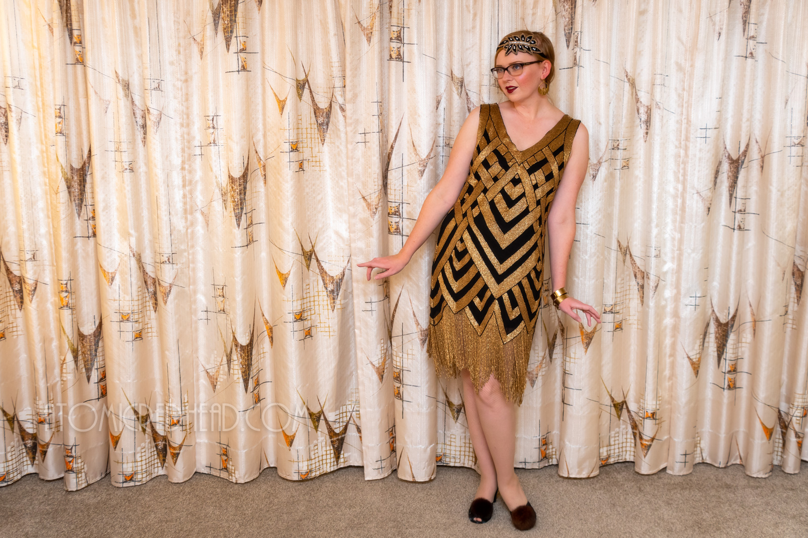 Myself, wearing a black and gold chevron patterned beaded flatter dress, with a black and gold headband.