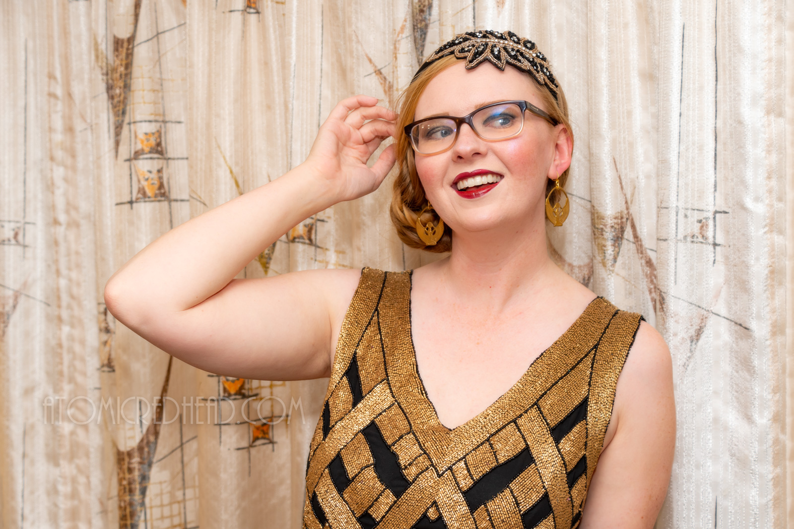 Myself, wearing a black and gold chevron patterned beaded flatter dress, with a black and gold headband.