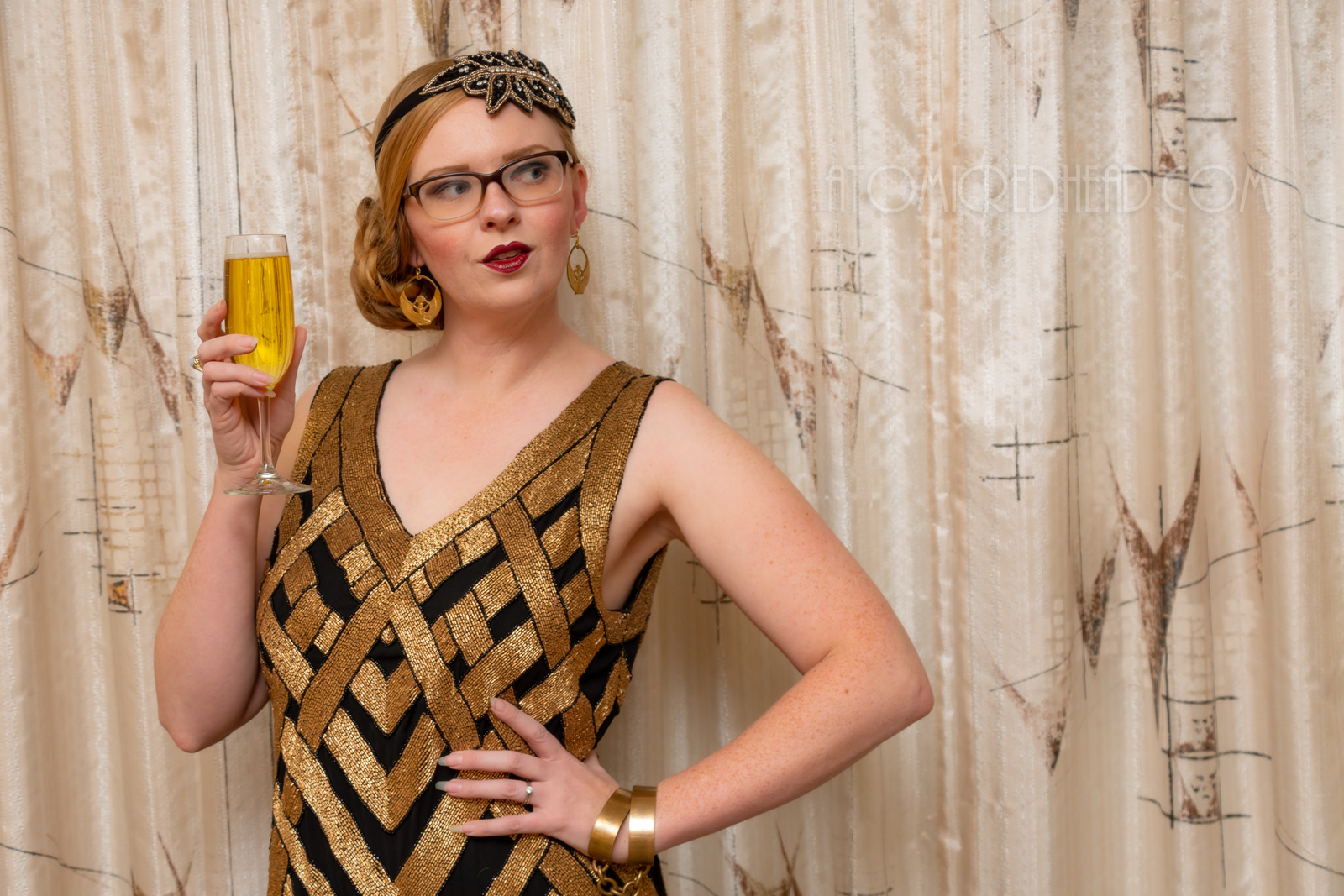 Myself, wearing a black and gold chevron patterned beaded flatter dress, with a black and gold headband.