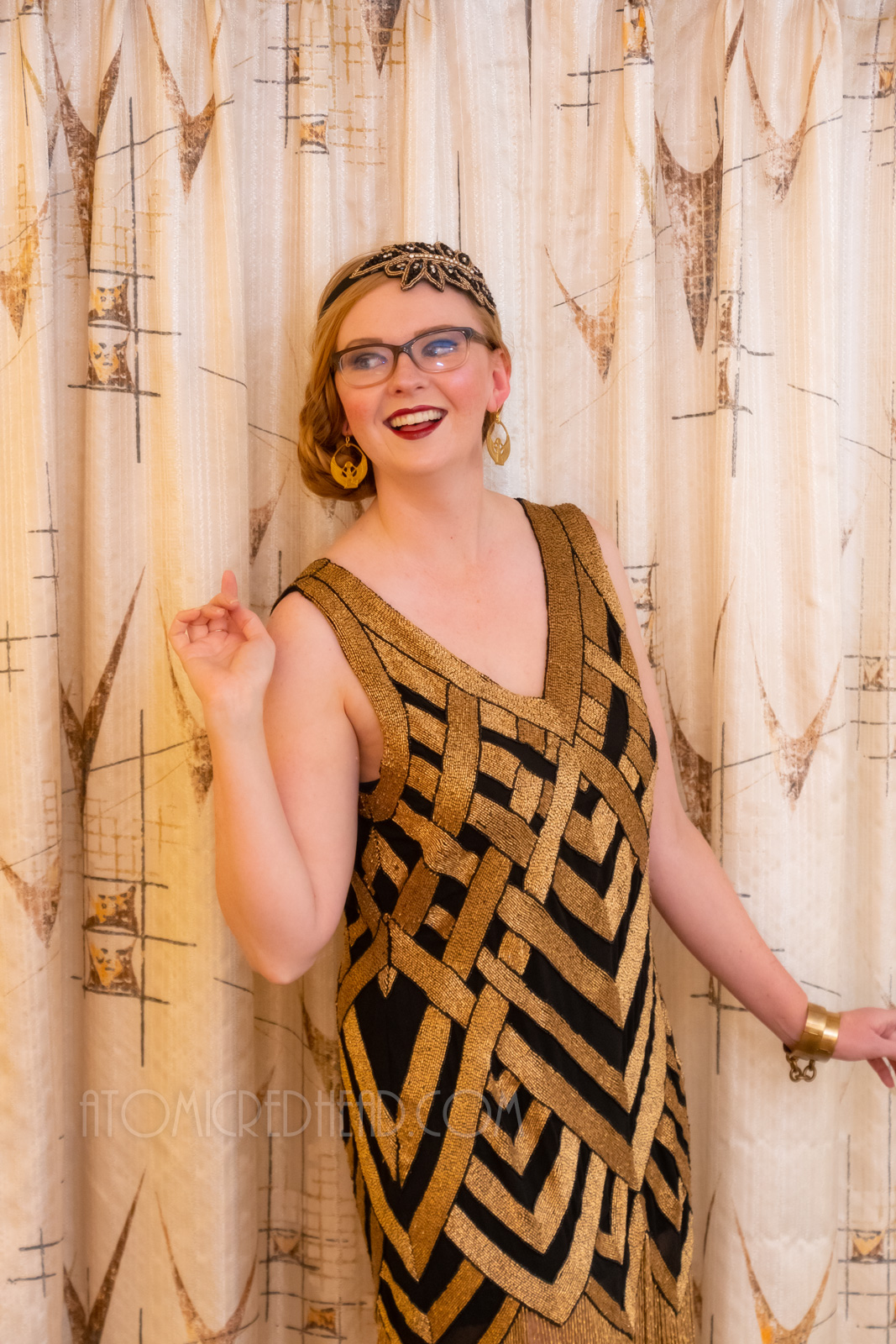 Myself, wearing a black and gold chevron patterned beaded flatter dress, with a black and gold headband.