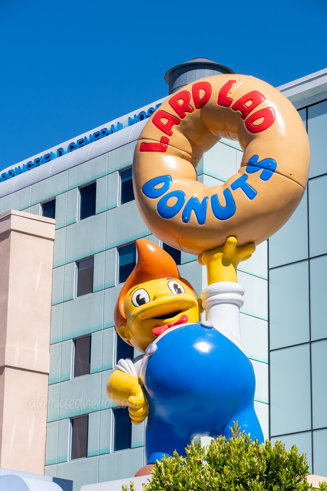 Statue atop Lard Lad Donuts, of a kid in overalls with cowlick hair holding a giant donut.