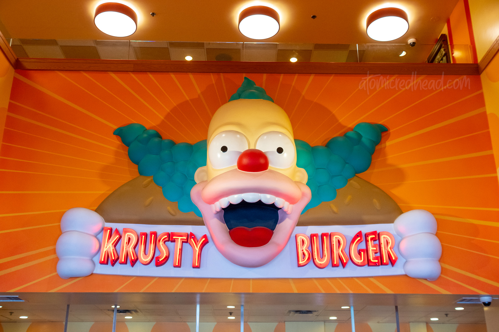Inside Krusty Burger, a massive head of Krusty the Klown beckons visitors.