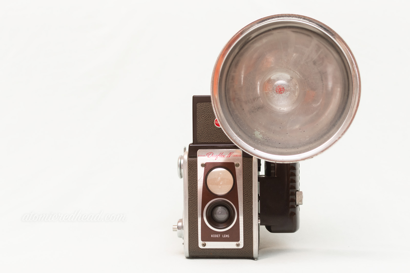 Kodak Duaflex IV. A brown and silver dual lens camera with a flash attachment. 