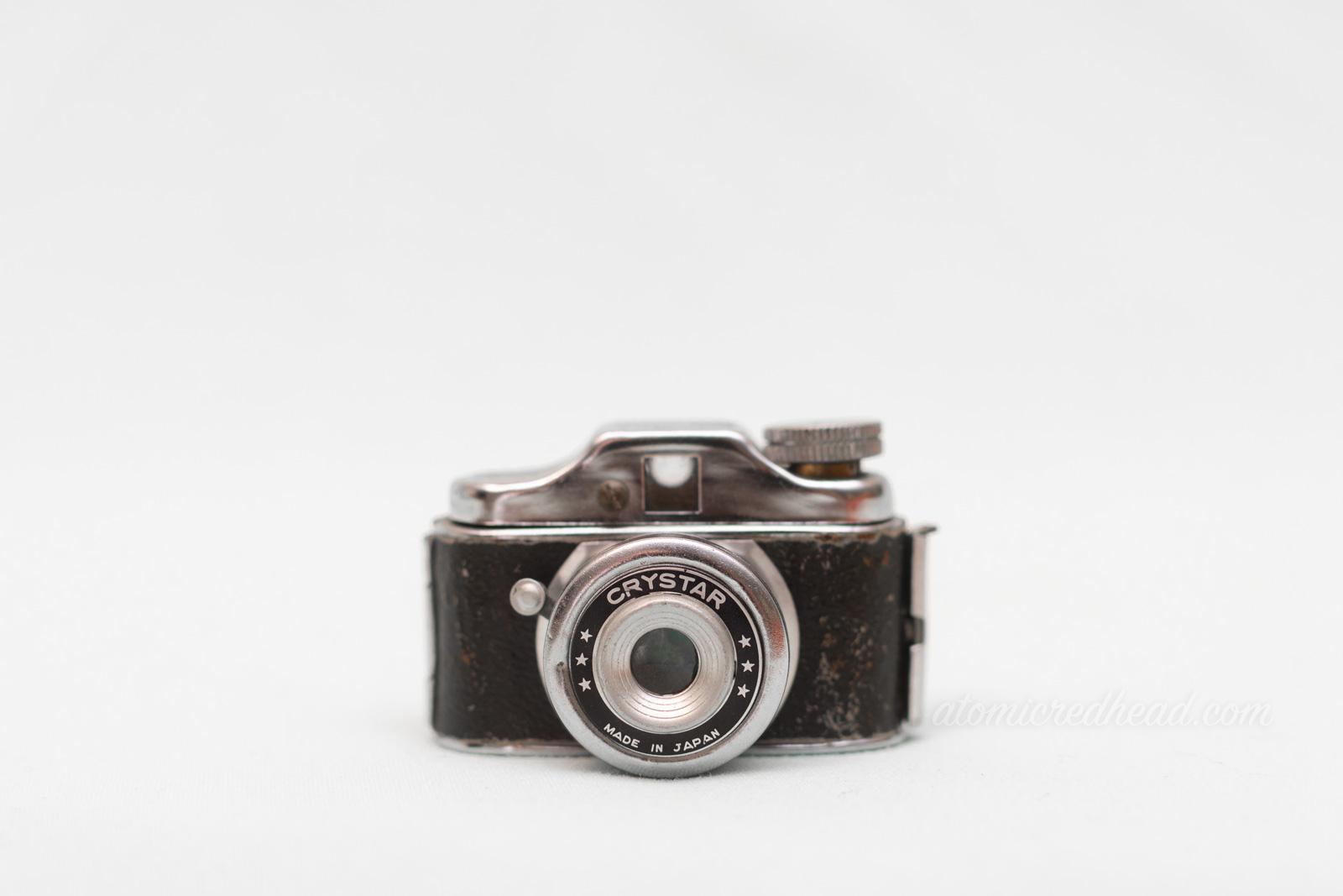 A very small rangefinder style camera of black and silver.