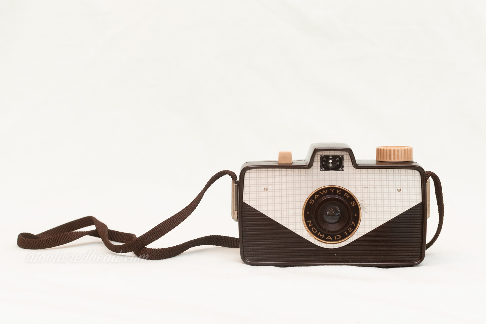 Sawyer Nomad 127. A rectangular brown camera with a triangular silver panel in front. The