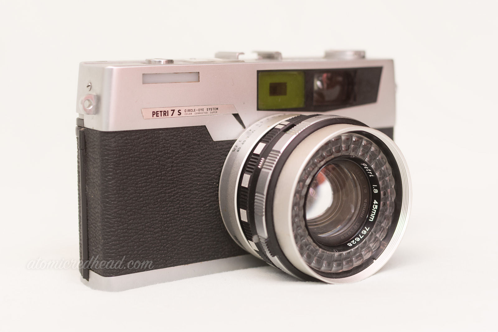Petri 7S. A black and silver rangefinder type camera with the flash built into the lens.