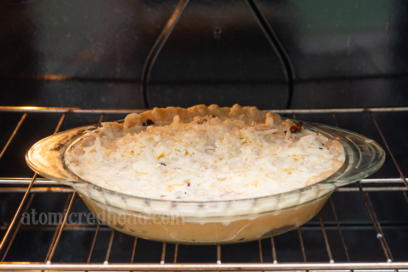 Unbaked quiche placed in the oven.