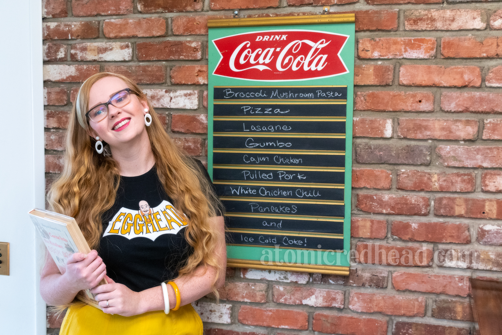 Myself standing against a brick wall, wearing a black shirt with a bat shape with text reading "Egghead"