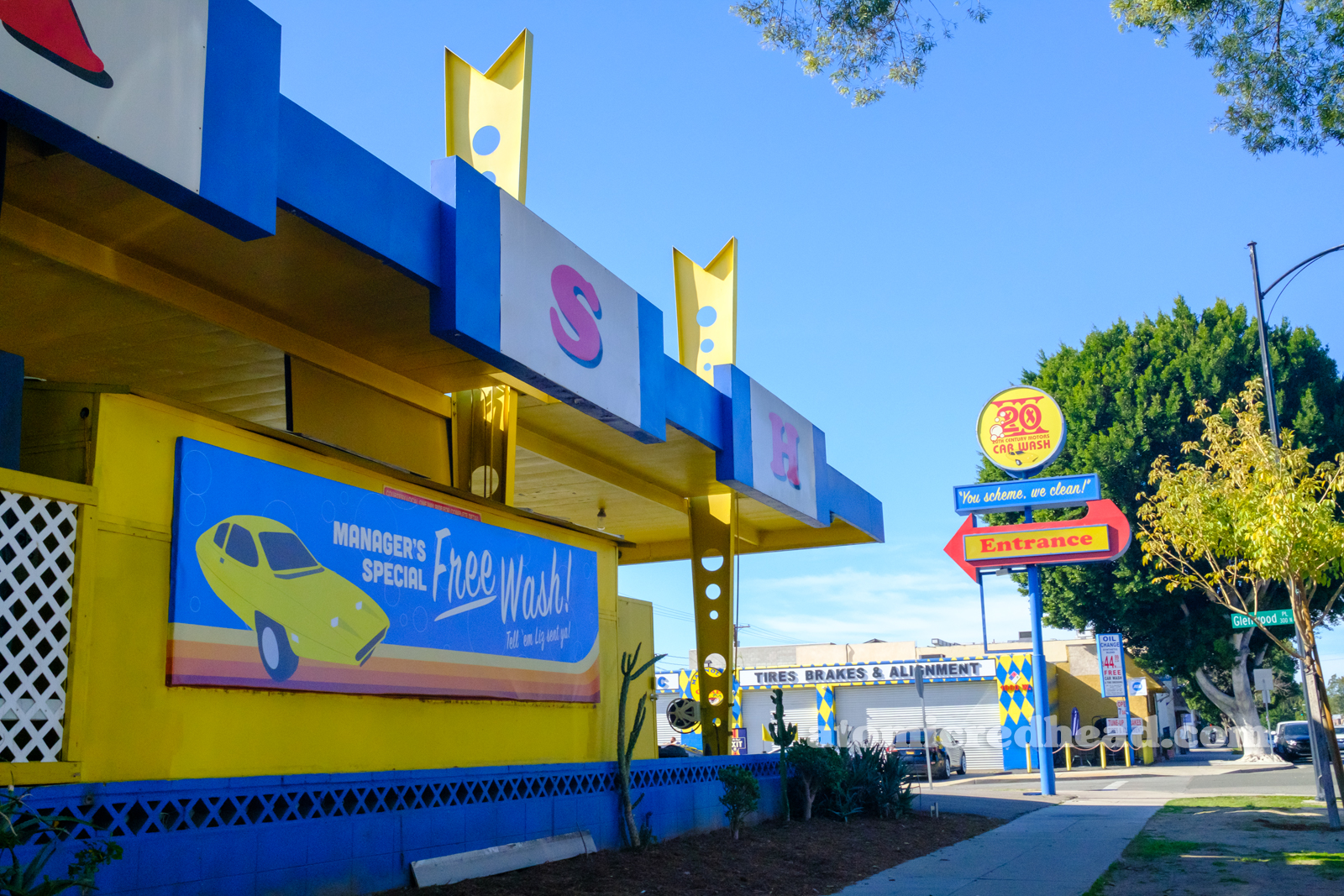 Side of the car wash, with a blue banner featuring a yellow Dale car and text reading "Manager's Special Free Wash Tell 'Em Liz Sent You."