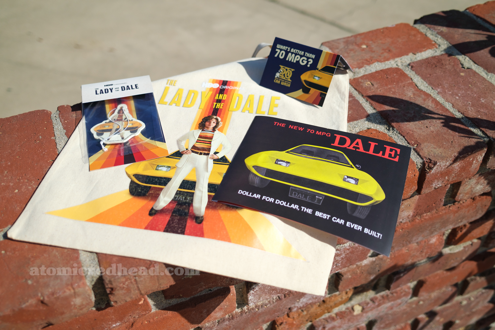 The swag bag and its contents, including a replica of the brochure, an air fresher of Liz and the Dale, and a gift card for Shell." 