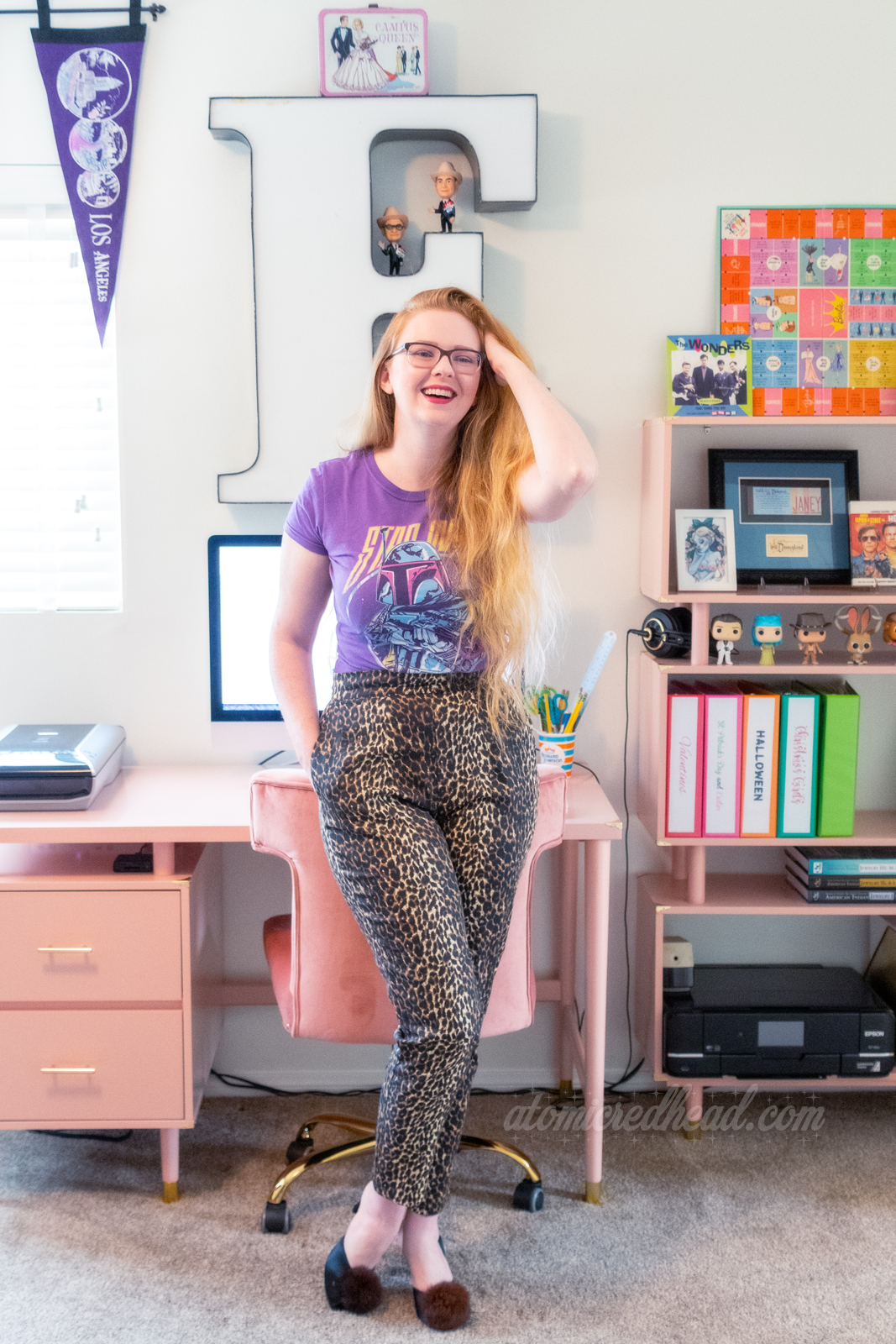 Myself, leaning against my chair in front of my pink desk. Hanging above the desk is a giant letter E. To the right of the desk is a matching bookcase.