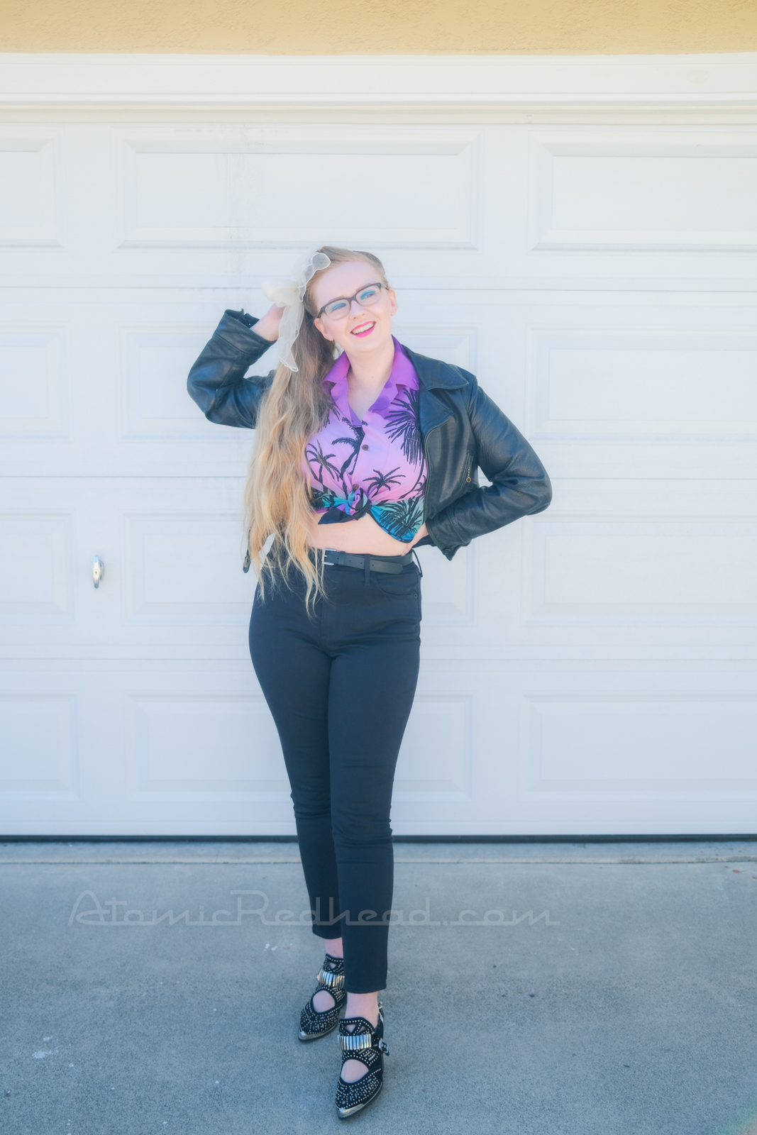 Myself standing in front of our garage door, wearing a black leather motorcycle jacket, purple and teal Hawaiian shirt, and black jeans.