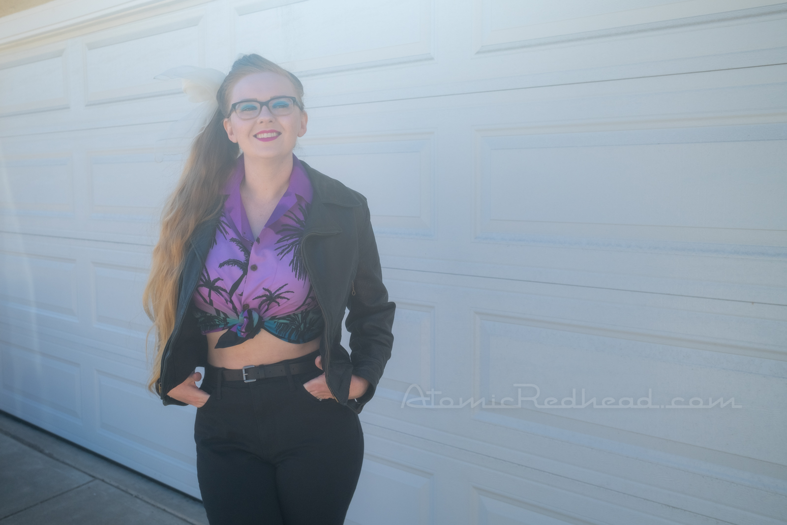 Myself standing in front of our garage door, wearing a black leather motorcycle jacket, purple and teal Hawaiian shirt, and black jeans.