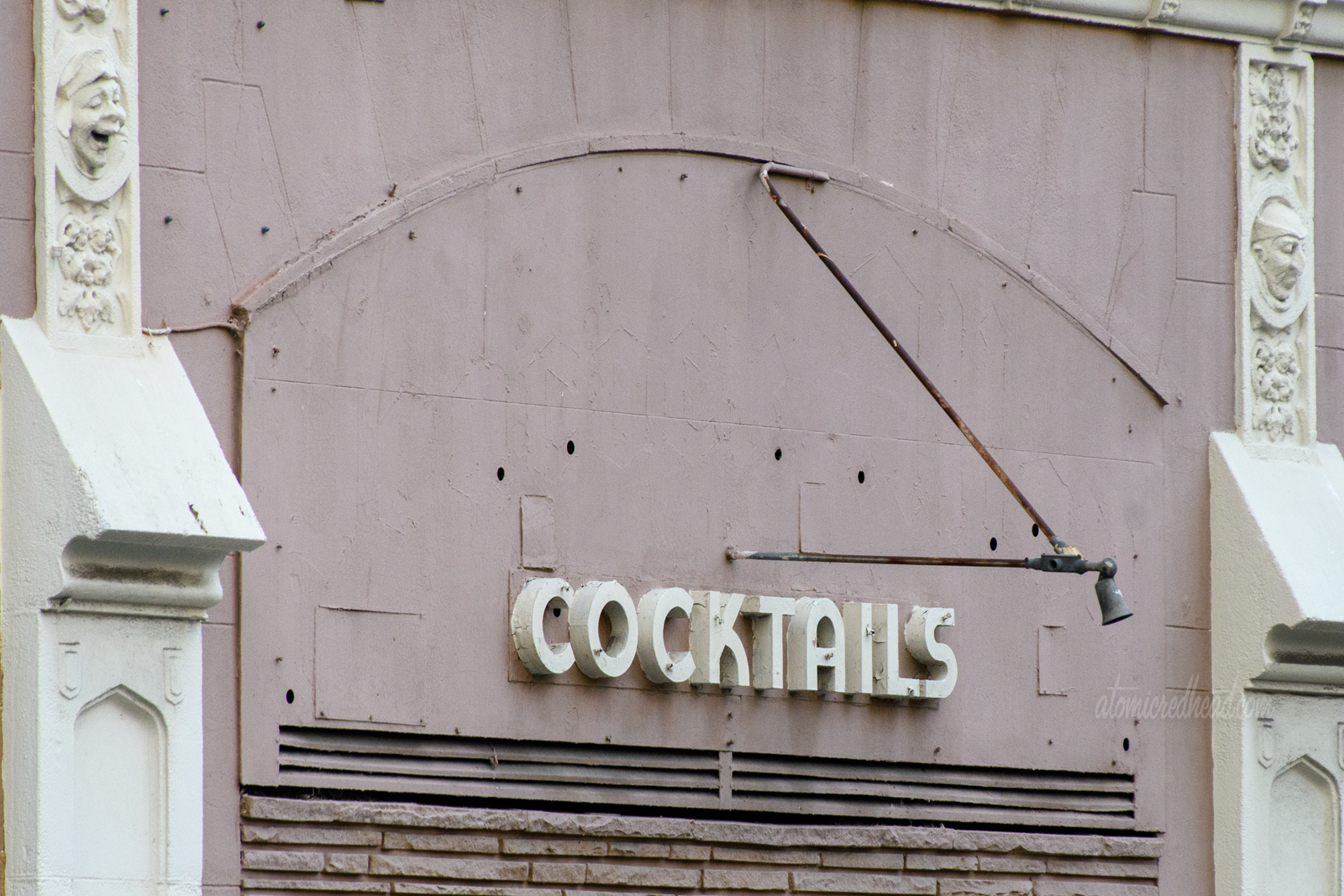 The remains of an unknown bar, all that is left are small deco letters spelled out "Cocktails"