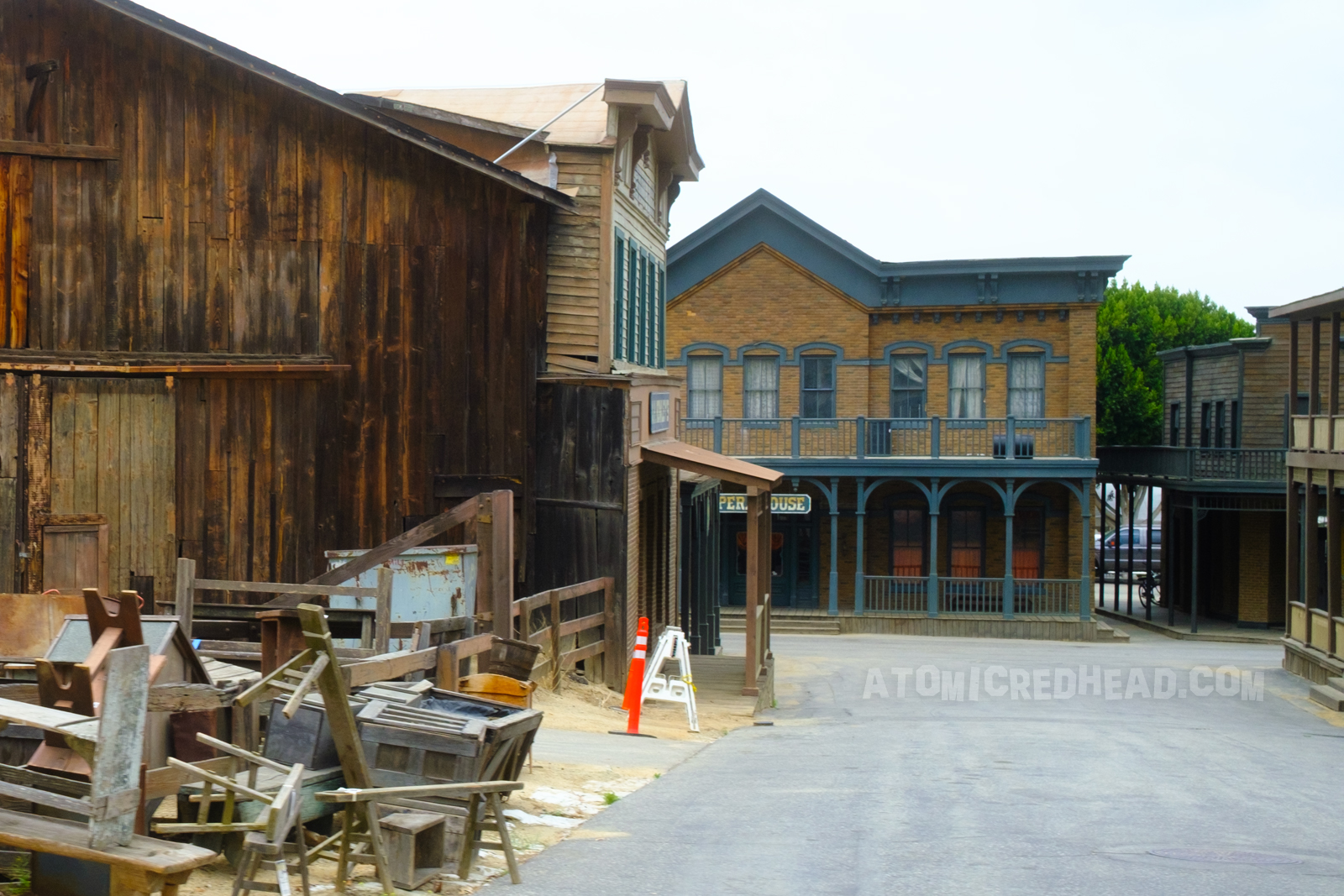 Six Points as it appears today. Weathered western buildings, some feature faux brick. Piles of props are on the left.