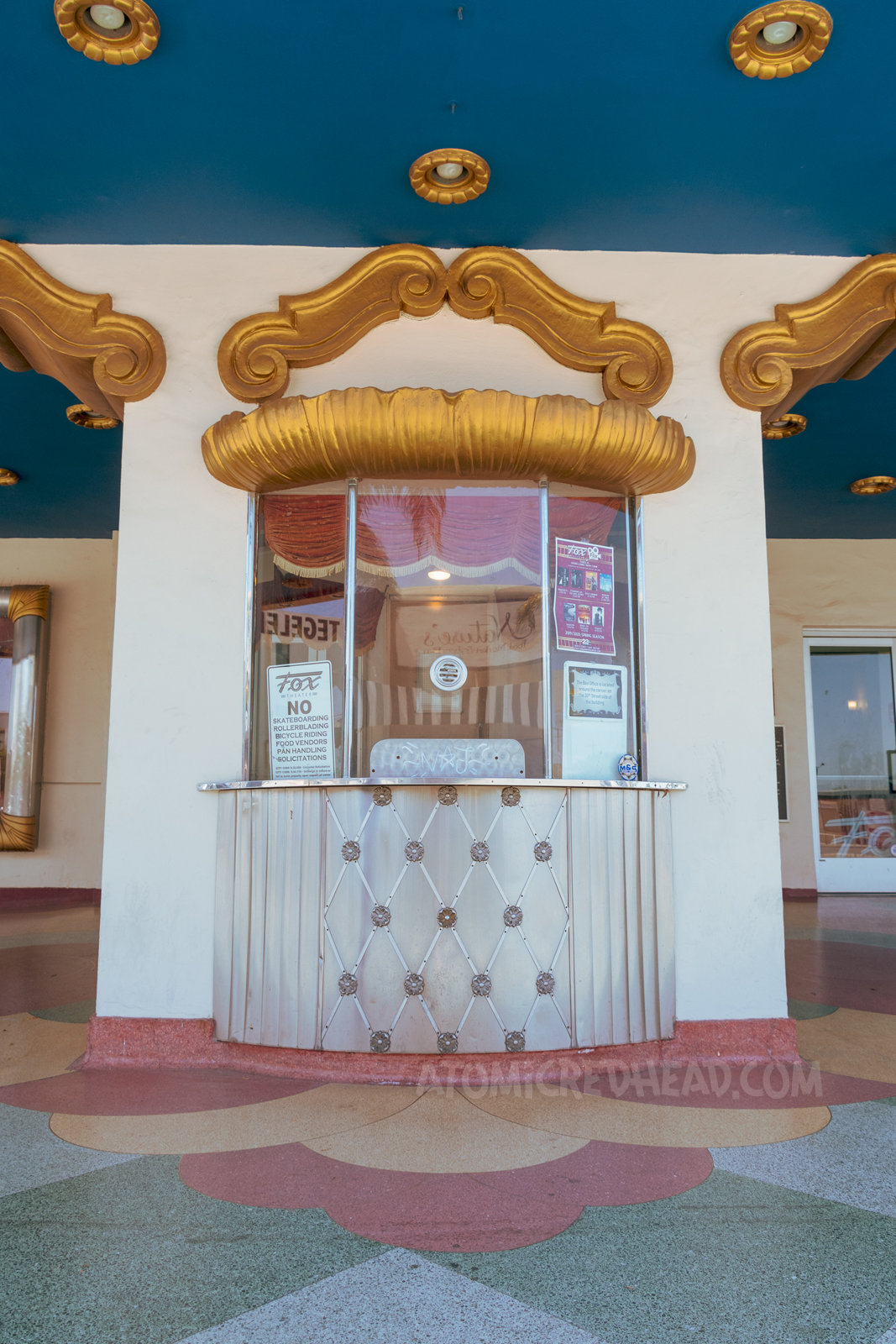 The box office, with gold trim around the top, and gold detailing below the window.