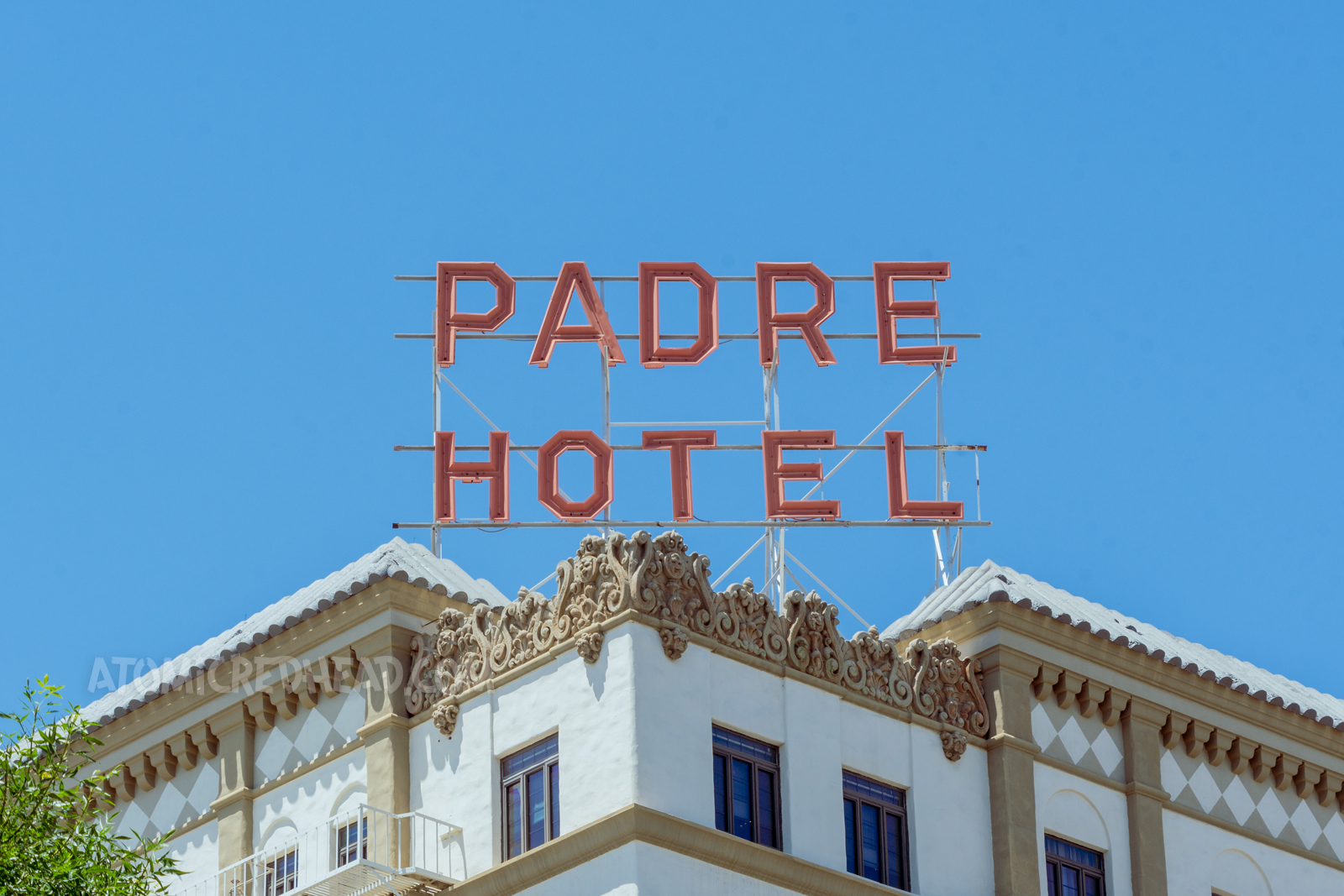 Large red letters sit atop the roof reading "Padre Hotel"