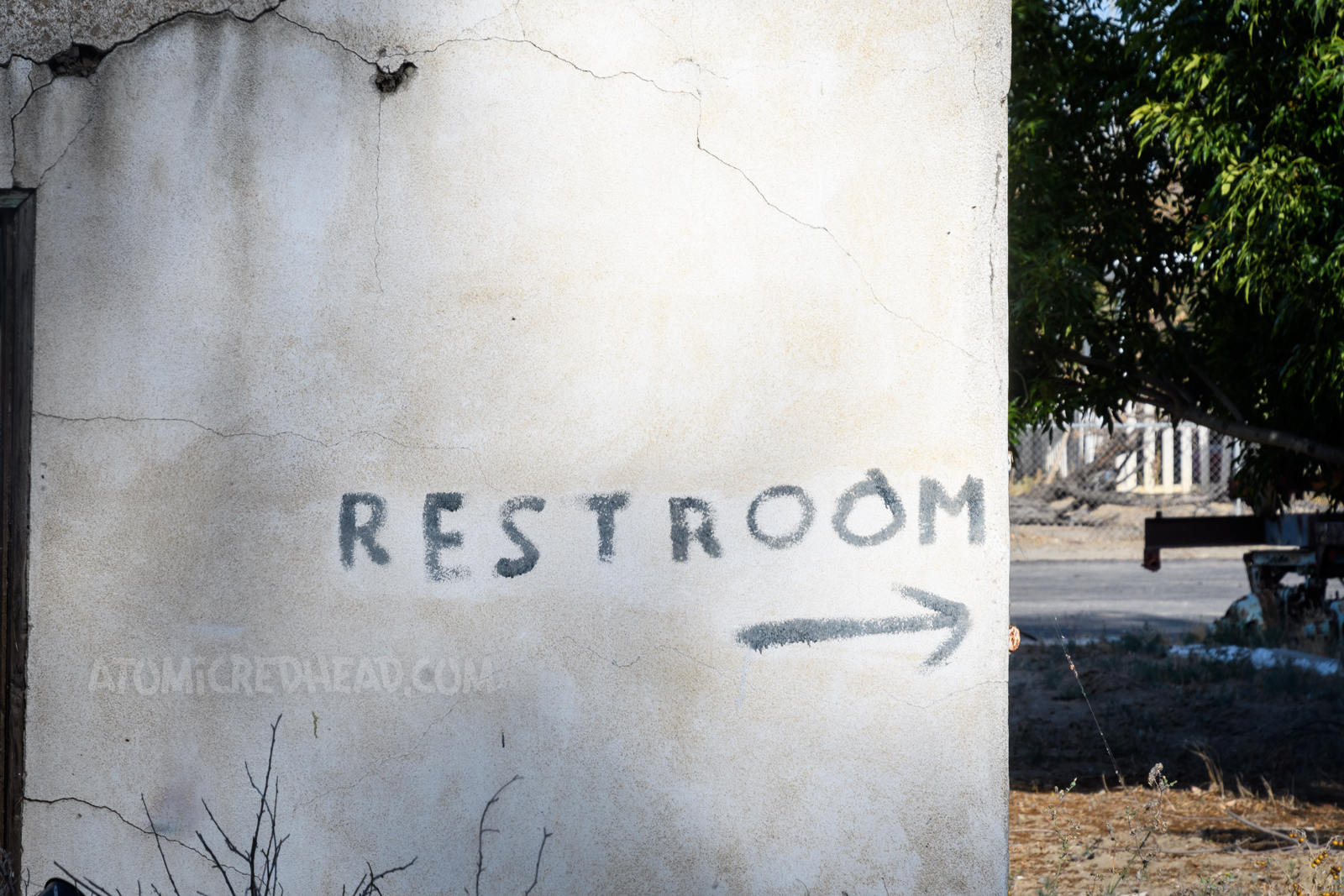 Hand painted text reading "Restroom" with a little arrow.