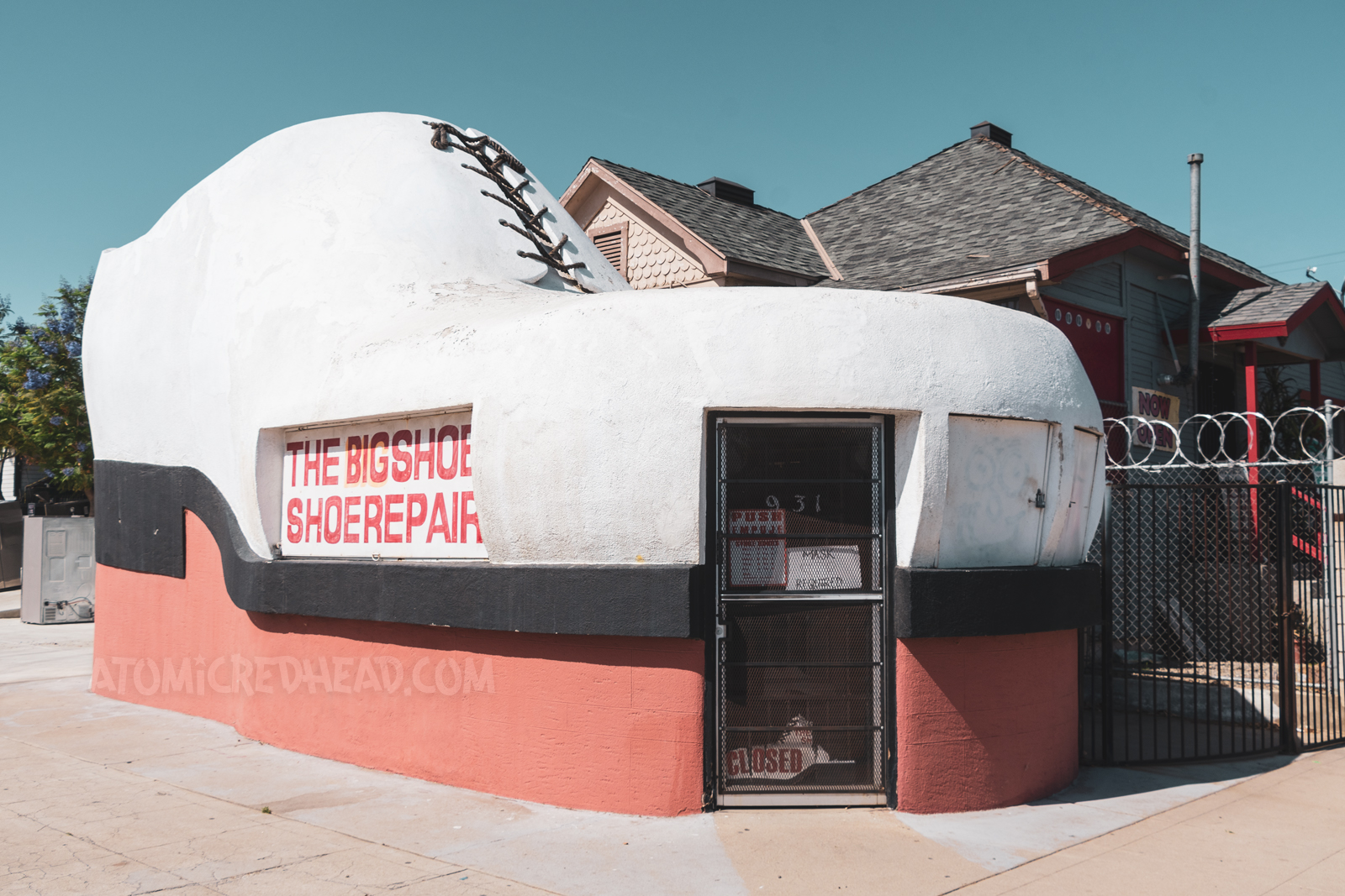 A shoe repair shop that is shaped like a gigantic shoe, complete with laces at the top.