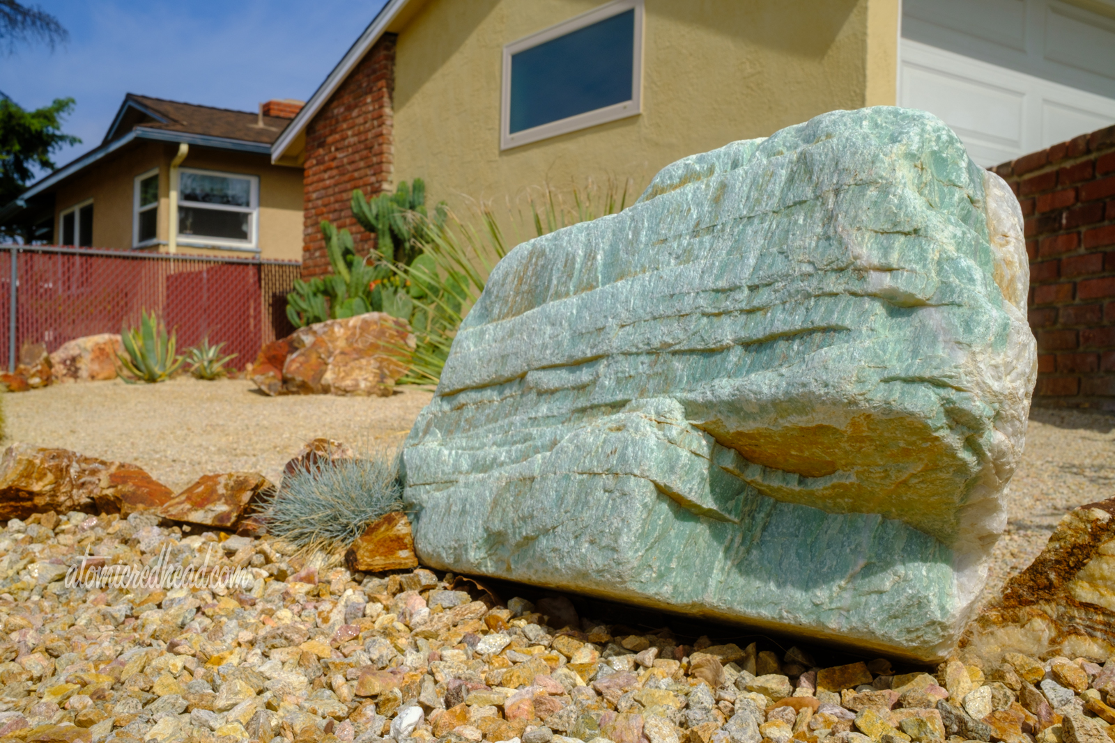 Close-up of a turquoise colored rock that sits along the edge of the path.