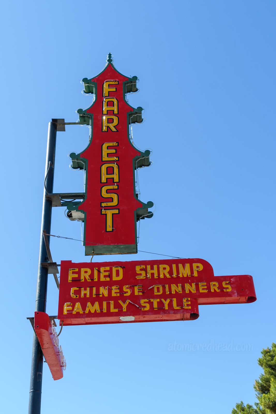 A neon sign shaped like a pagoda building, painted red with yellow letters reading "Far East Fried Shrimp Chinese Dinners Family Style"