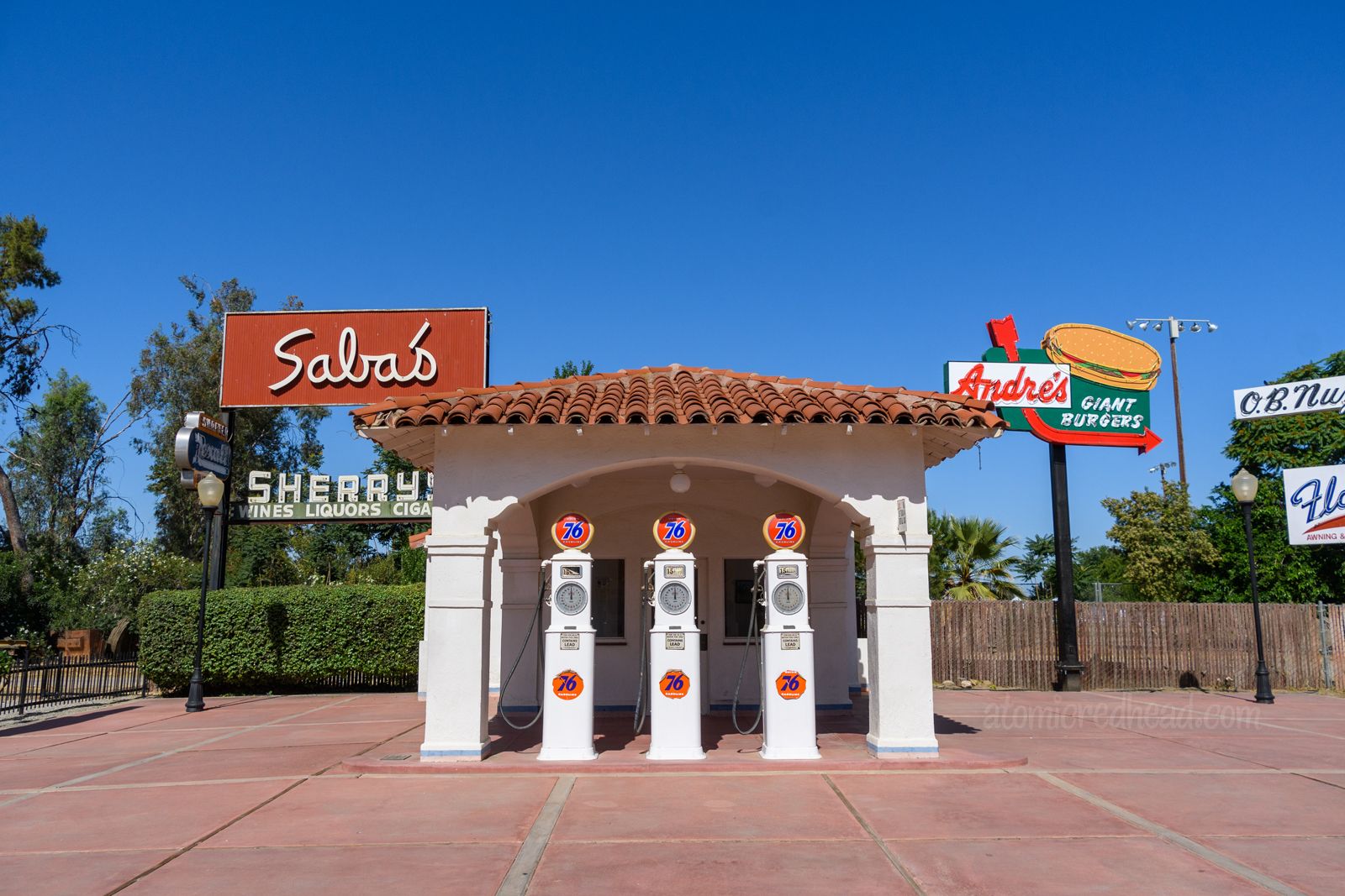 An old gas station from the 1930s, done in a Spanish Revival style with red tile roof and white stucco.