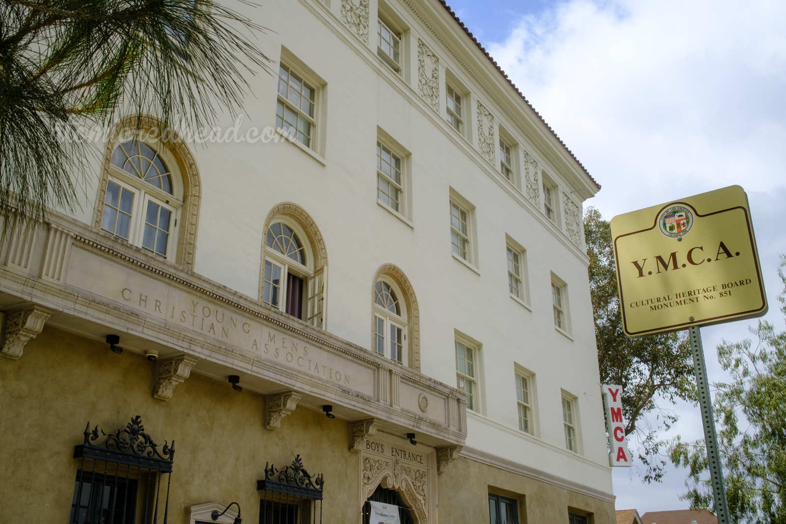 The YMCA at an angle, a metal sign off to the side reads "YMCA Cultural Heritage Board Monument No. 851"