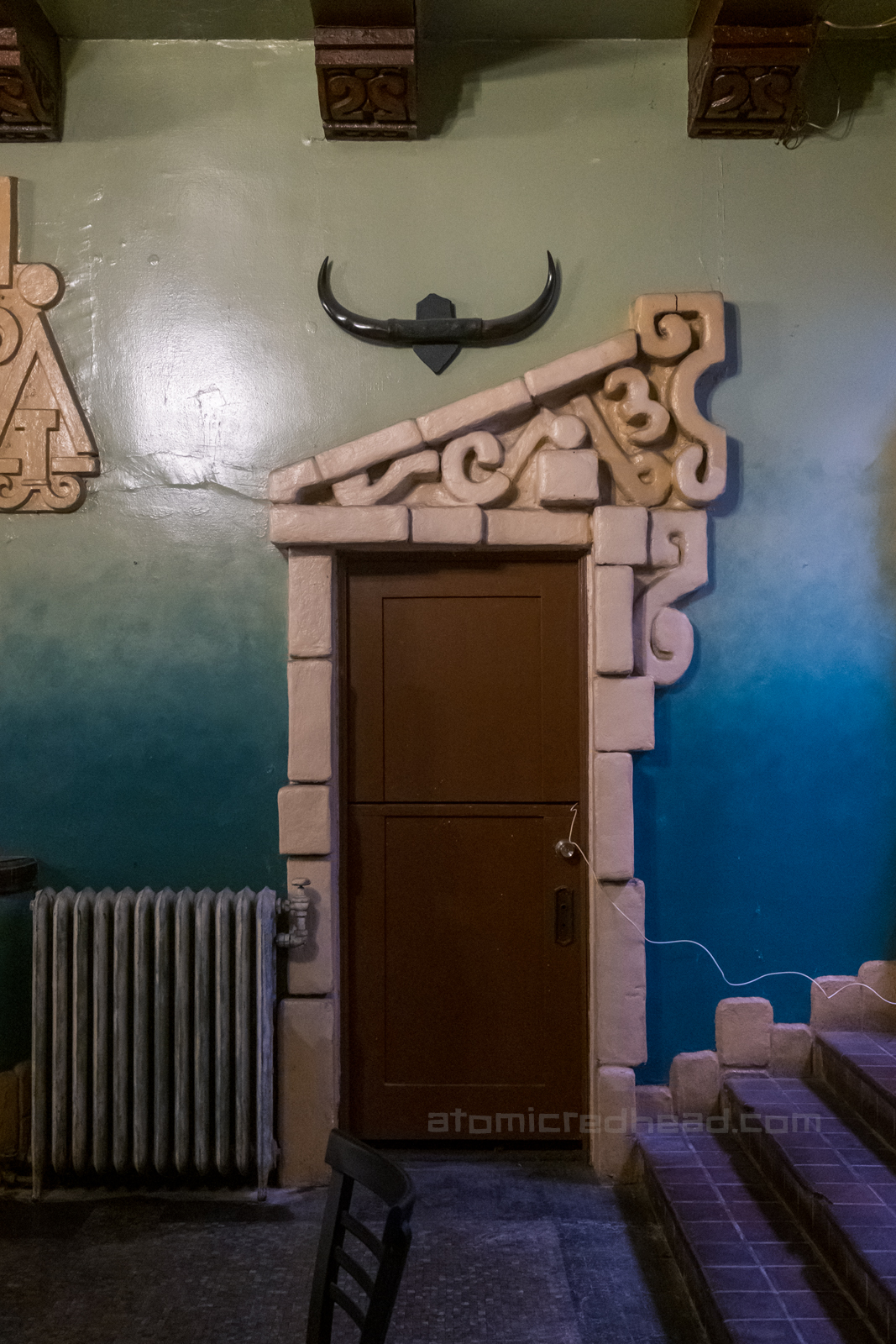 A doorway in the lobby which features an asymmetrical design above.