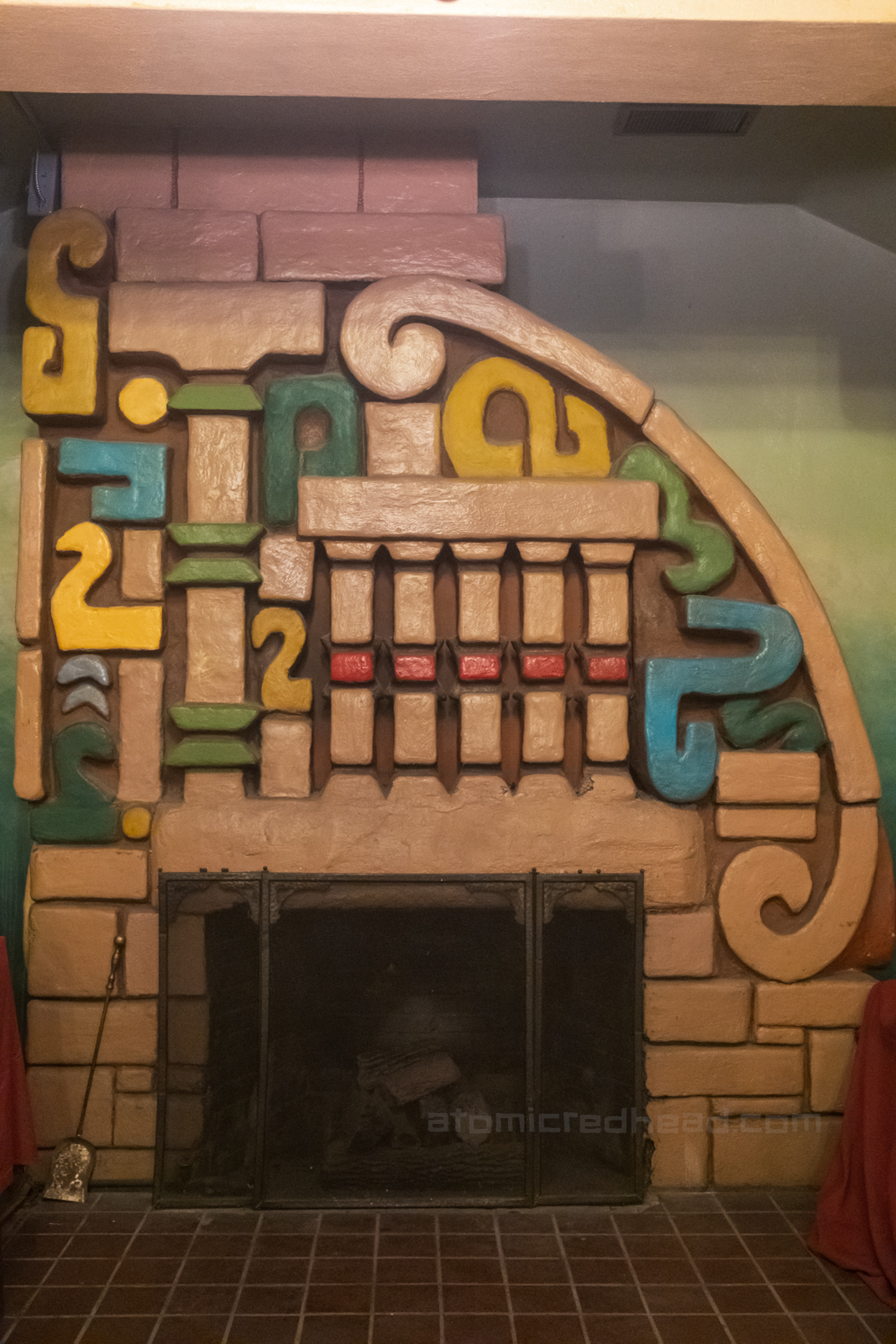 Fireplace in the lobby, which features an intricate painted Mayan design above the fireplace opening.