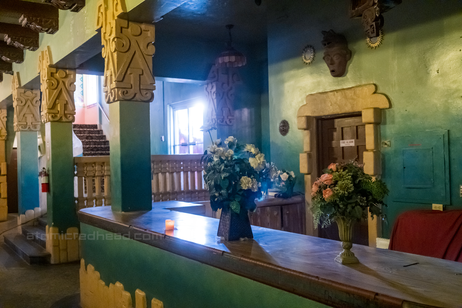 The check in counter in the lobby, which features pillars of Mayan inspired decor at the top.