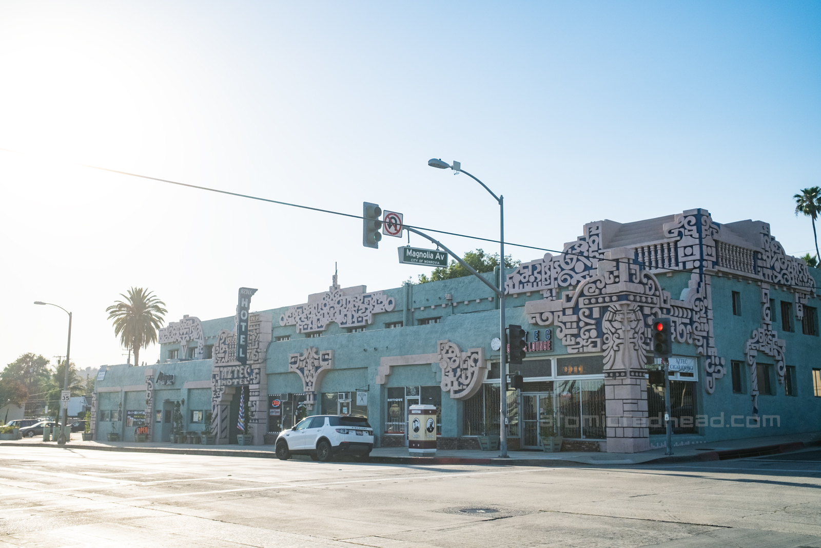 Exterior of the Aztec, a teal painted structure with various Mayan influenced designs along the corners, edges, and doorways.