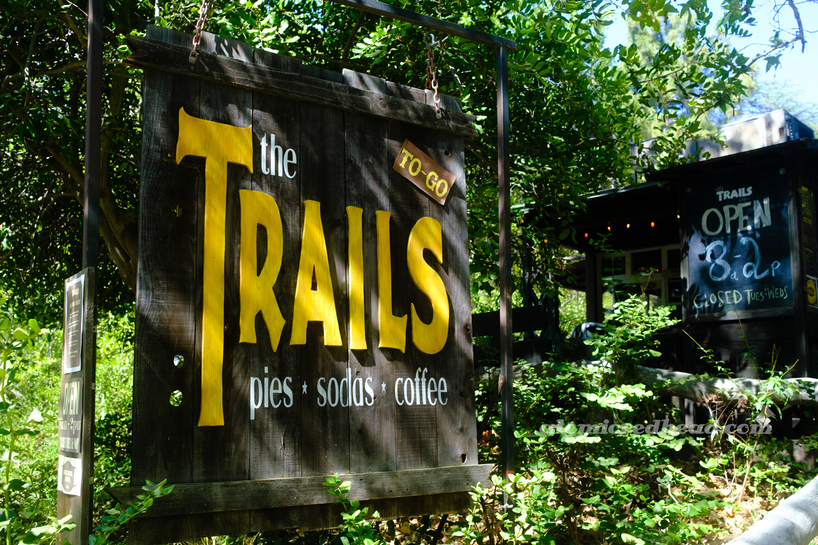 A large wooden sign reading "The Trails Pies Sodas Coffee"
