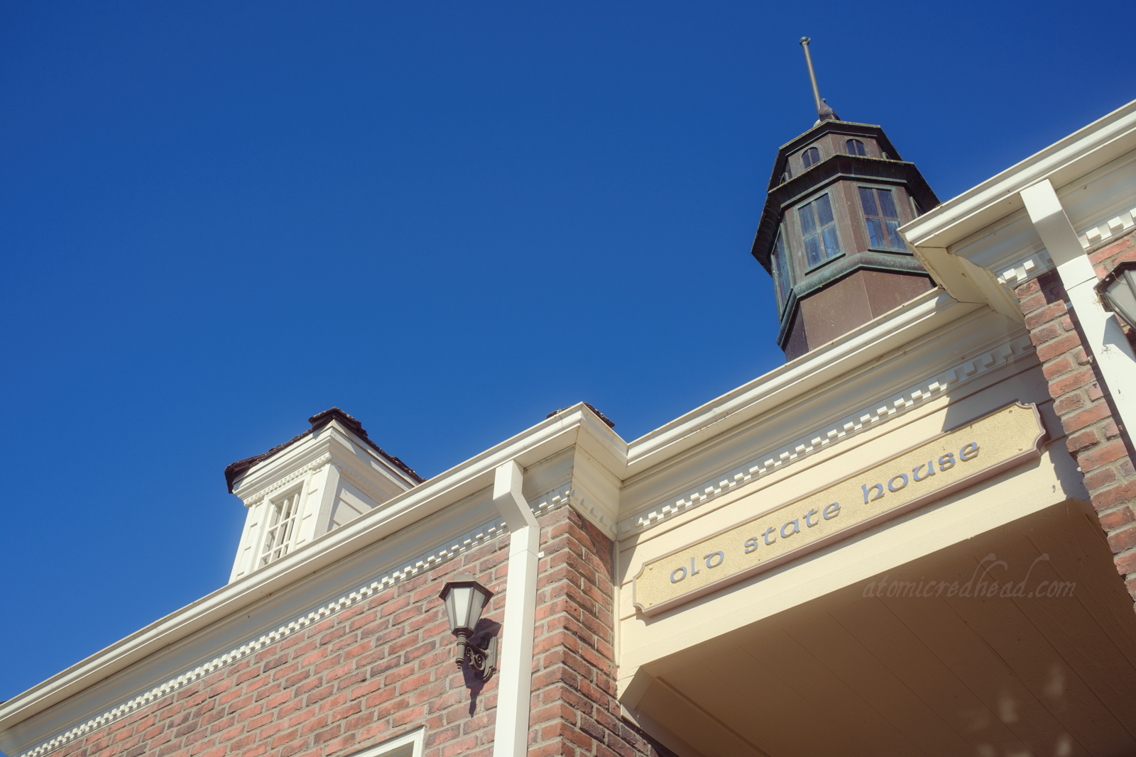 A brick and white trim New England style building with a sign reading "Old State House"