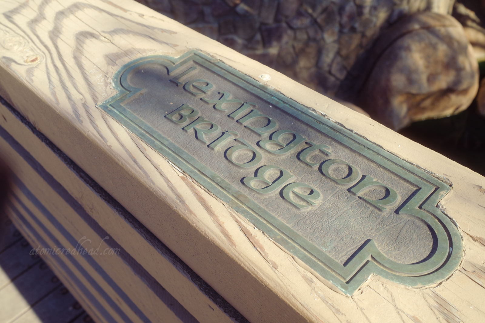 A small sign on the railing of a bridge reads "Lexington Bridge."