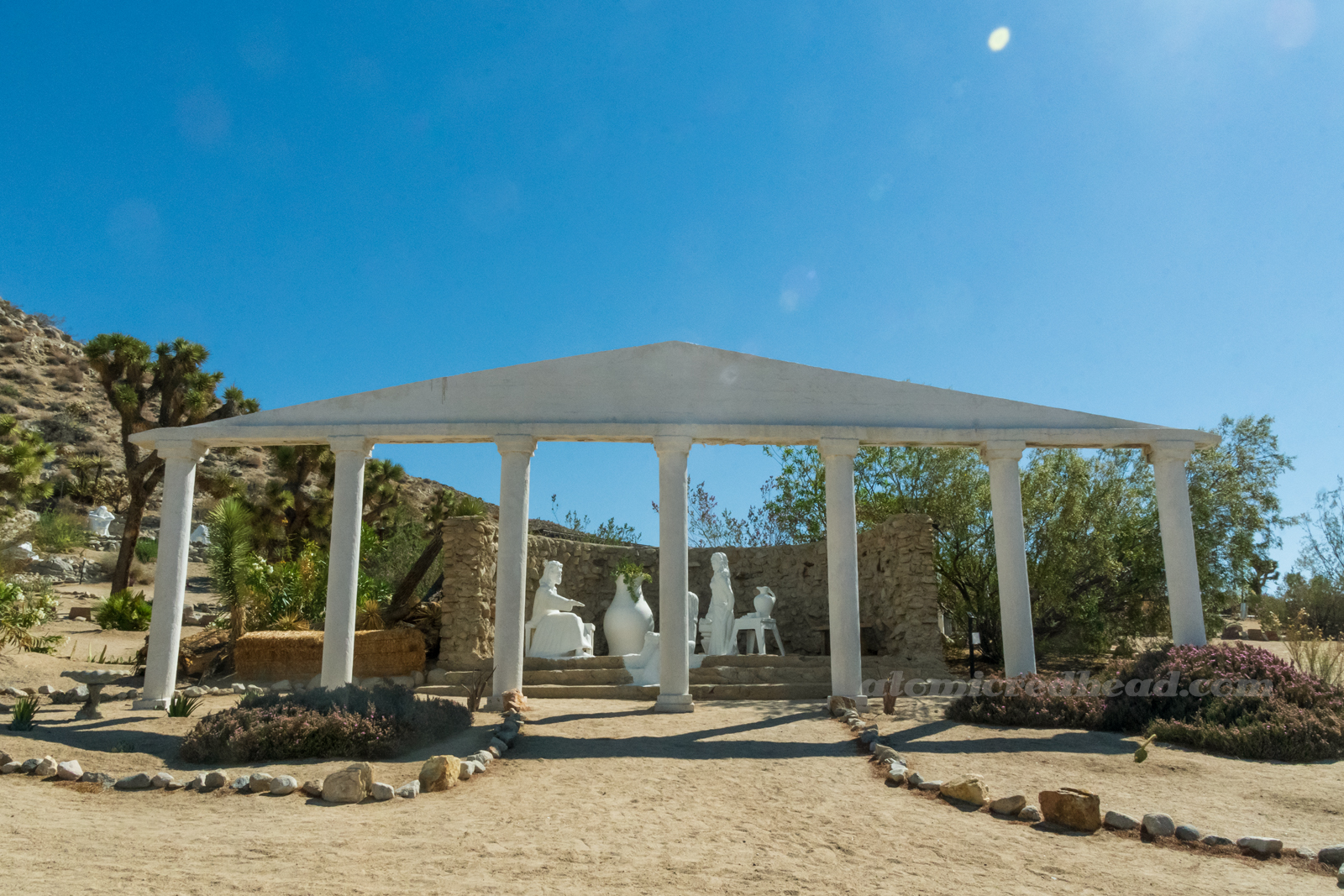 A row of columns behind which are statues, including Jesus and two women.